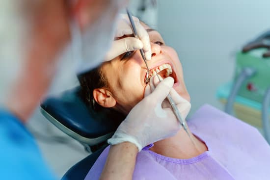 A-Patient-receiving-a-dental-checkup-from-a-dentist-in-a-modern-dental-office.-The-dentist-is-using-a-dental-mirror-and-probe-to-examine-the-patients-teeth-ensuring-oral-health-The-Alignify.jpg - Oralcare